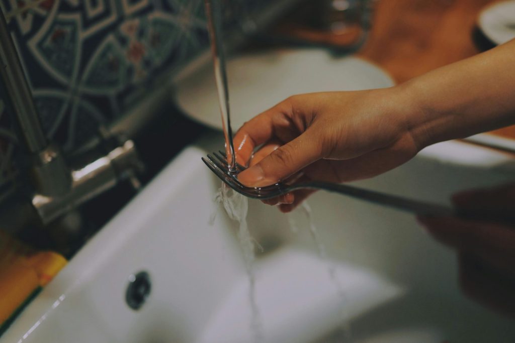 Lavando un tenedor bajo agua

