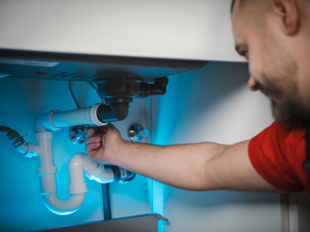 Hombre arreglando tuberías de cocina

